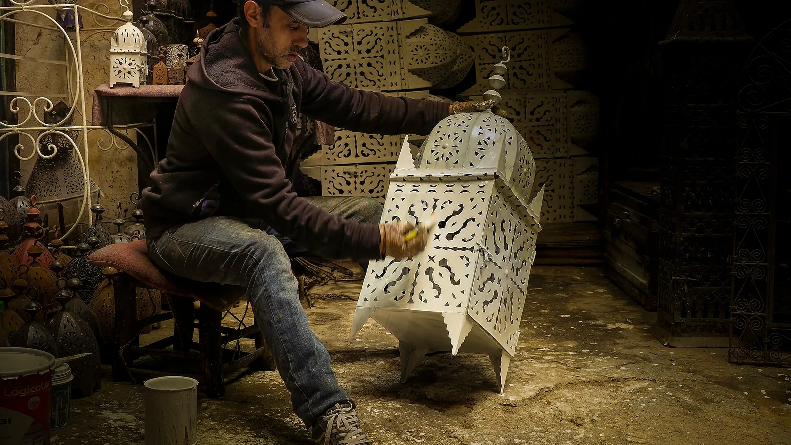 Artisan peignant une lampe dans la médina de Marrakech.